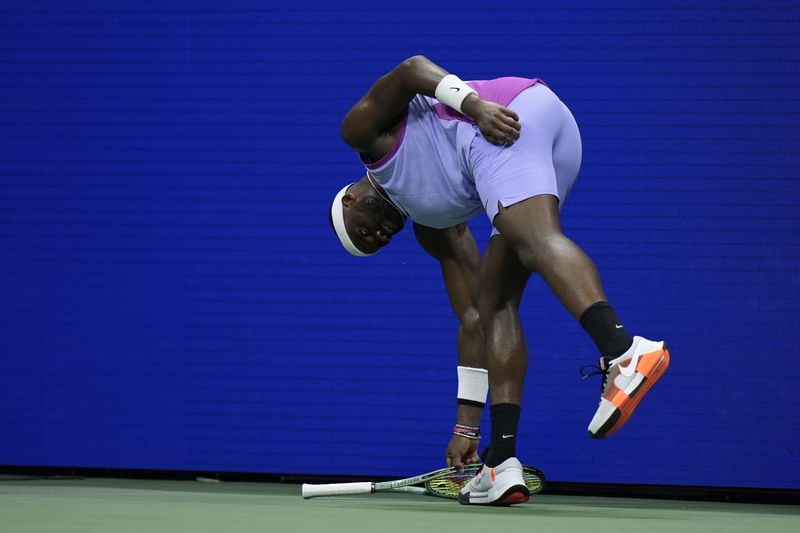 Frances Tiafoe, of the United States, picks up his racket during the men's singles semifinals against Taylor Fritz, of the United States, of the U.S. Open tennis championships, Friday, Sept. 6, 2024, in New York. (AP Photo/Seth Wenig)