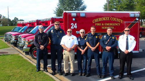 Standing with Cherokee Fire & Emergency Services' new ambulances are (from left) Dean Hege, Sgt. Joel Sciranko, EMS Chief Nate Sullivan, Dr. Jill Mabley, Mason Williams, Ben Kiefer and Operations Chief Shane West.