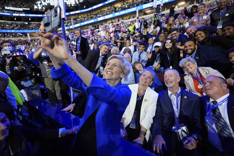 Sen. Elizabeth Warren, D-Mass., takes a selfie with Massachusetts delegates during the Democratic National Convention Wednesday, Aug. 21, 2024, in Chicago. (AP Photo/Paul Sancya)