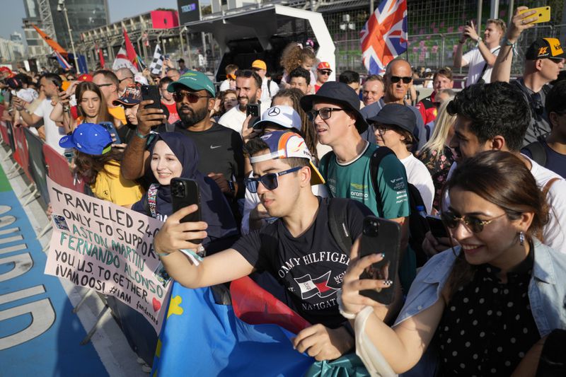 Spectators enjoy a pre-race track walk at the Baku circuit, in Baku, Azerbaijan, Thursday, Sept. 12, 2024. (AP Photo/Sergei Grits)