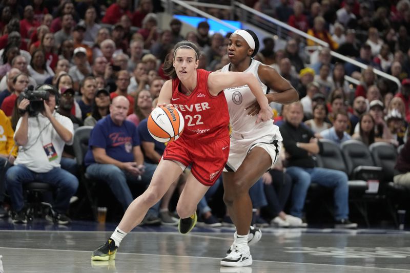 Indiana Fever's Caitlin Clark (22) goes to the basket against Las Vegas Aces' Jackie Young (0) during the first half of a WNBA basketball game, Wednesday, Sept. 11, 2024, in Indianapolis. (AP Photo/Darron Cummings)