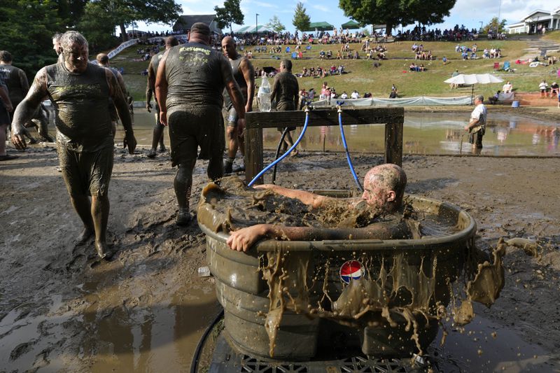 A Muckaneer's player dunks himself in a tub to clean off after a football game at the 2024 Mud Bowl Sunday, Sept. 8, 2024, in North Conway, N.H. (AP Photo/Robert F. Bukaty)