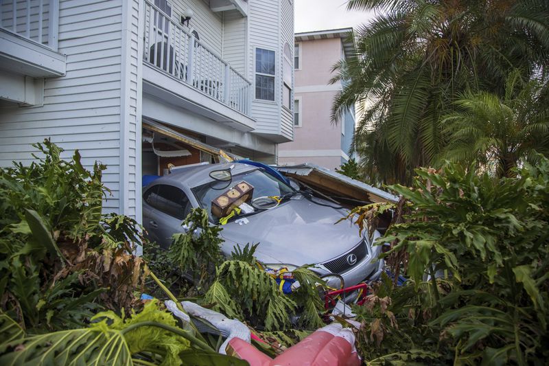 A vehicle sits outside of its garage after storm surge from Hurricane Helene, Saturday, Sept. 28, 2024, in Madeira Beach, Fla. (Luis Santana/Tampa Bay Times via AP)