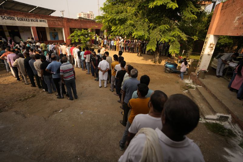 People queue up to cast their vote at a polling booth during the third phase of the Jammu and Kashmir Assembly election in Jammu, India, Tuesday, Oct. 1, 2024. (AP Photos/Channi Anand)