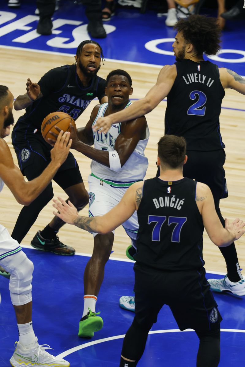 Minnesota Timberwolves guard Anthony Edwards (5) drives against Dallas Mavericks guard Luka Doncic (77) and center Dereck Lively II (2) during the first half of Game 2 of the NBA basketball Western Conference finals, Friday, May 24, 2024, in Minneapolis. (AP Photo/Bruce Kluckhohn)