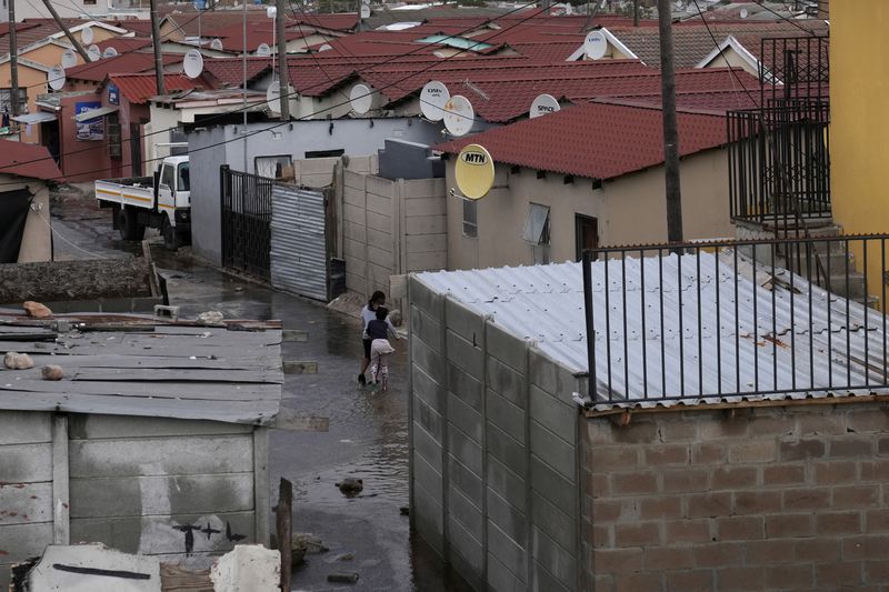 Water flows through Khayelitsha, Cape Town, South Africa, Thursday July 11, 2024. The South African city of Cape Town and surrounding areas have been hit by more storms, ripping roofs off houses and causing widespread flooding. (AP Photo/Nardus Engelbrecht)