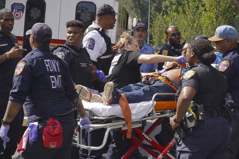 First responders tend to a man injured during a shooting at the West Indian Parade, Monday, Sept. 2, 2024, in the Brooklyn borough of New York. (Nancy Siesel via AP)