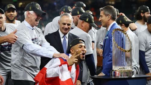 110221 HOUSTON: Braves outfielder Eddie Rosario takes in a closer view of the Commissioner's Trophy while getting a pat on the back from Chairman and CEO Terry McGuirk after beating the Astros in game 6 to win the World Series on Tuesday, Nov. 2, 2021, in Houston.   “Curtis Compton / Curtis.Compton@ajc.com”