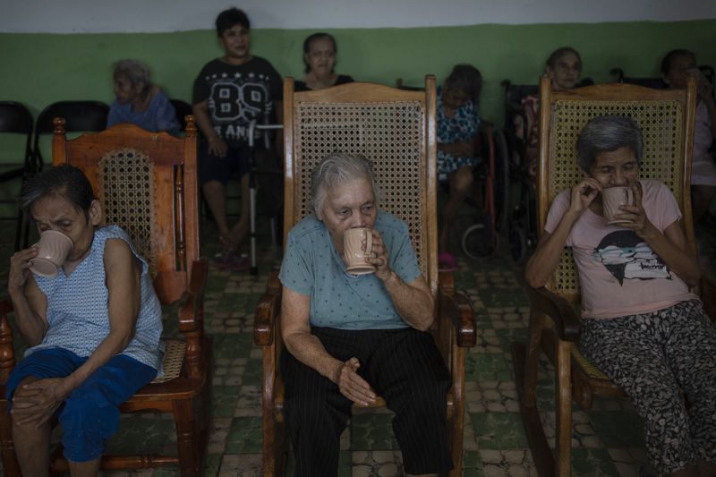 Women sit by the window of the Cogra nursing home to cool off from high temperatures in Veracruz, Mexico, Sunday, June 16, 2024. Victims in Veracruz have made up nearly a third of Mexico's heat-related deaths as temperatures have reached 100 degrees in the humid Mexican gulf state. (AP Photo/Felix Marquez)