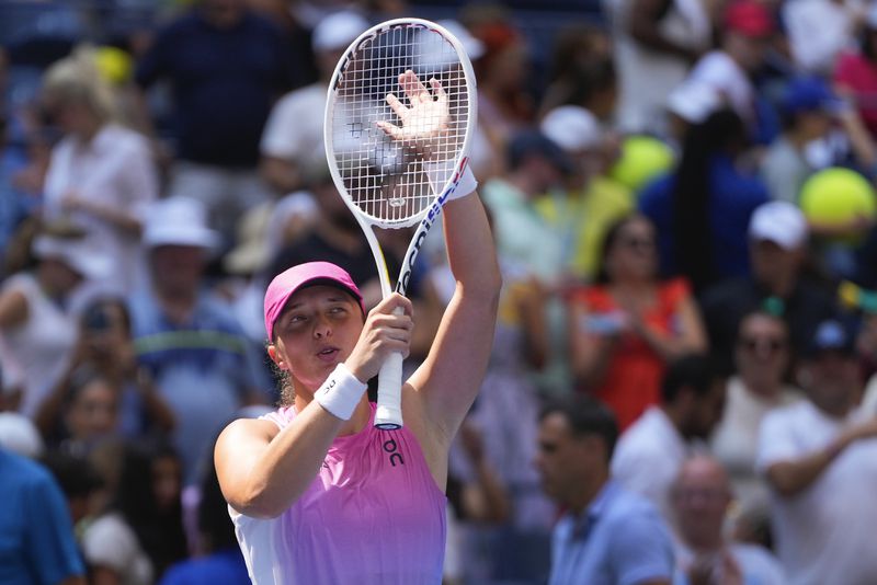 Iga Swiatek, of Poland, waves to fans after defeating Kamilla Rakhimova, during the first round of the U.S. Open tennis championships, Tuesday, Aug. 27, 2024, in New York. (AP Photo/Kirsty Wigglesworth)