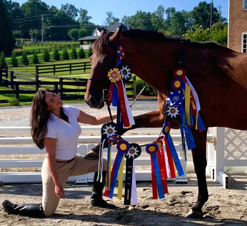 Joy Lim Nakrin with her rescued thoroughbred racehorse that she retrained as a show jumper to win all these ribbons in competition. (Courtesy of Joyous Acres)