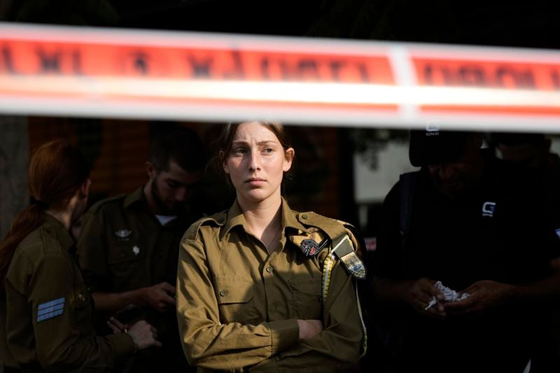 An Israeli soldier looks at the scene of a stabbing and shooting attack where Israel's Magen David Adom rescue service said one person was killed and several others were wounded in Beersheba, Israel, Sunday, Oct. 6, 2024. (AP Photo/Tsafrir Abayov)