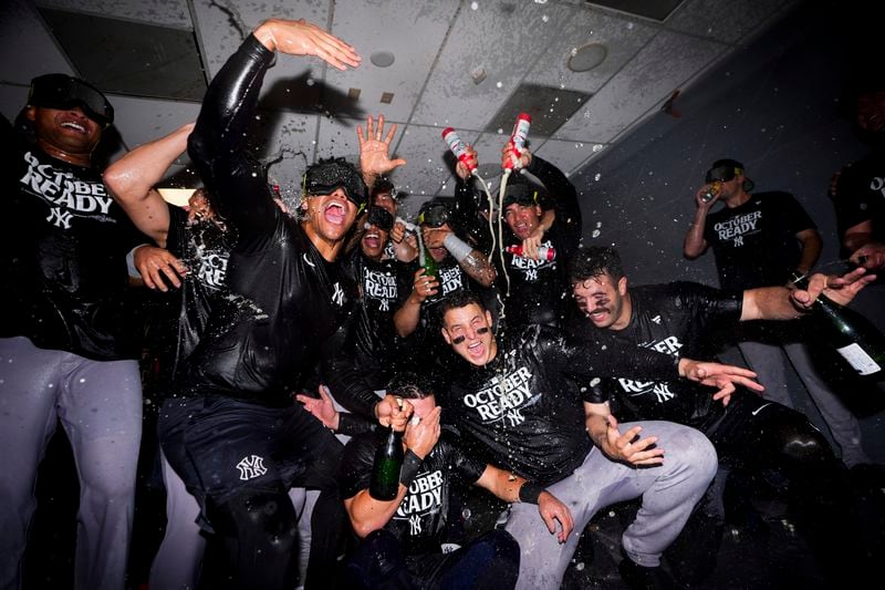 The New York Yankees celebrate clinching a playoff spot after a 2-1 win in 10 innings over the Seattle Mariners in a baseball game Wednesday, Sept. 18, 2024, in Seattle. (AP Photo/Lindsey Wasson)