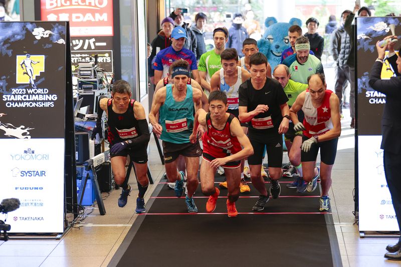 In this photo provided by ISF/Meeting, competitors start a race of Stairclimbing World Championships in Osaka, western Japan, Nov. 19, 2023. (ISF/MEETING via AP)