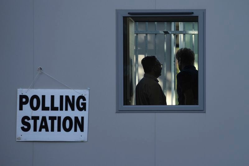 People vote in a temporary polling station next to Norbiton railway station London Thursday, July 4, 2024. Britain goes to the polls Thursday after Prime Minister Rishi Sunak called a general election. (AP Photo/Kin Cheung)