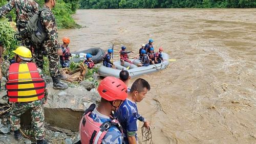 In this handout photograph released by Nepal Armed Police force, shows rescuers looking for the survivors after two buses were swept by a landslide off the highway and into a swollen river near Simaltal, about 120 kilometers (75 miles) west of the capital, Kathmandu, Nepal, Friday, July 12, 2024. (Nepal Armed Police Force via AP)