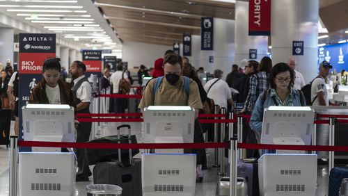 Travelers use kiosks to check in for flights in the Delta Airlines ticketing area at the Los Angeles International Airport in Los Angeles, Friday, Aug. 30, 2024. (AP Photo/Jae C. Hong)