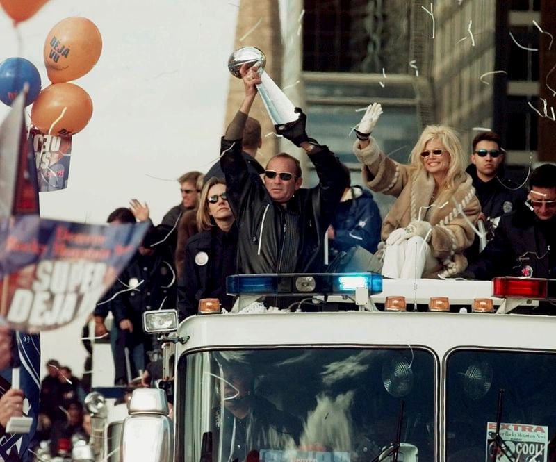 FILE - Denver Broncos owner Pat Bowlen holds the Vince Lombardi Super Bowl trophy over his head and his wife, Annabelle, right, waves, as they ride a fire truck through downtown Denver in a victory parade Feb. 1, 1999. The Broncos returned to Denver, Monday after winning Super Bowl XXXIII. (AP Photo/Ed Andrieski, File)