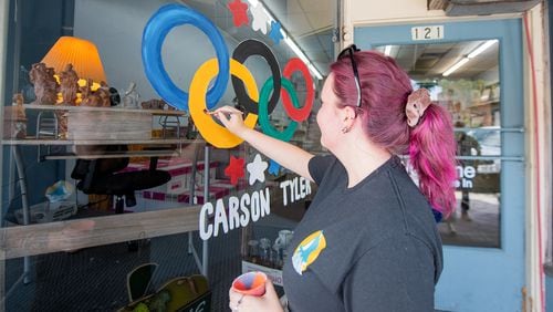 Amber Moore, a local artist from Moultrie Art Center draws Paris Olympic paintings on shop windows in Moultrie on Wednesday, July 24, 2024.  (Ziyu Julian Zhu / AJC)