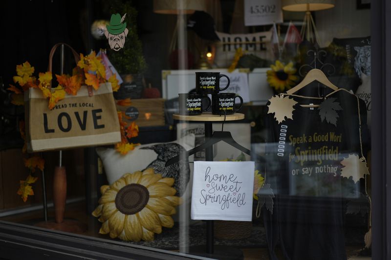 Items supporting Springfield, Ohio, including the slogan "Speak a Good Word for Springfield or say nothing," and "Hope Sweet Springfield," are displayed in the Champion City Guide & Supply shop window, Tuesday, Sept. 17, 2024, in Springfield, Ohio. (AP Photo/Carolyn Kaster)