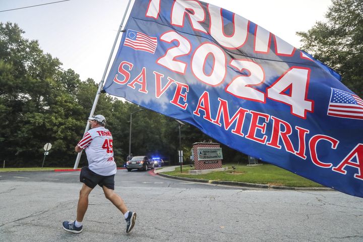 August 24, 2023 Atlanta: Mike Boatman from Evansville, Indiana carries a large Trump flag along Rice Street late Thursday morning, Aug. 24, 2023 where there were more than 100 protestors gathered outside the jail, and they were prepared to wait for hours until the anticipated arrival of former President Donald Trump this afternoon. (John Spink / John.Spink@ajc.com)


