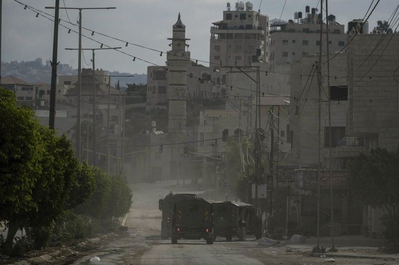 A convoy of Israeli military armored vehicles is seen during an army raid in Tulkarem, West Bank, on Tuesday, Sept. 3, 2024. (AP Photo/Majdi Mohammed)