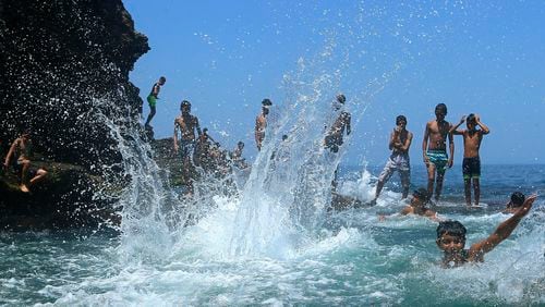 FILE - Youth play at the beach in a western part of Algiers, Monday, July 17, 2023. The young people who make up more than half of Algeria's population are so disenchanted that they may not vote in next month's presidential election. (AP Photo/Anis Belghou, File)