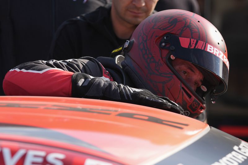 Keanu Reeves climbs out of his car following a GR Cup Series auto race at Indianapolis Motor Speedway, Saturday, Oct. 5, 2024, in Indianapolis. (AP Photo/Darron Cummings)