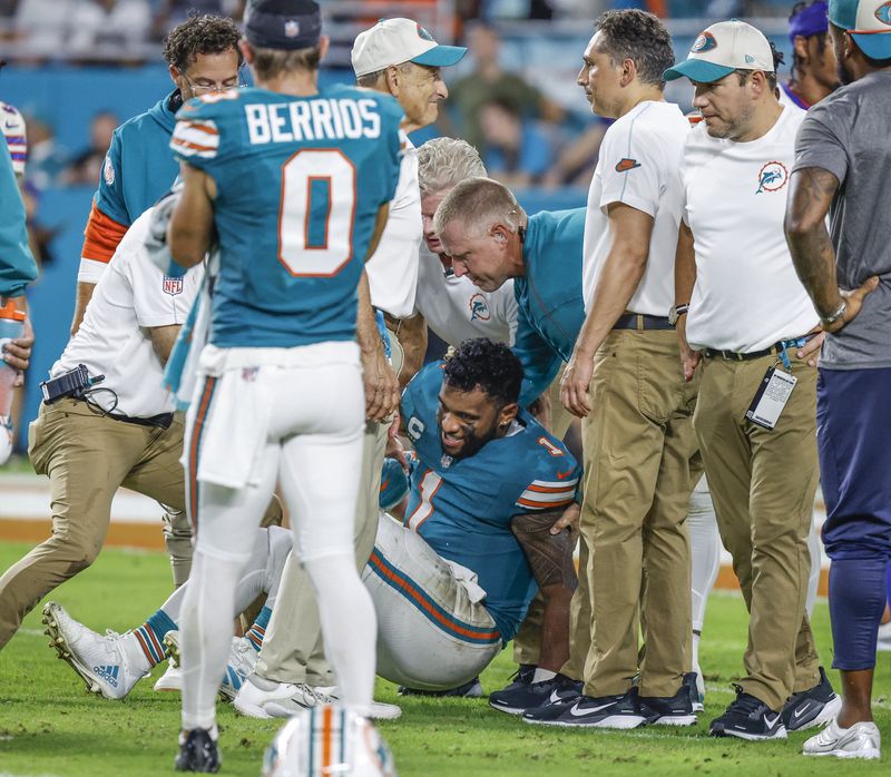 Miami Dolphins quarterback Tua Tagovailoa (1) is assisted after an injury in the third quarter of an NFL football game against the Buffalo Bills in Miami Gardens, Fla., Thursday, Sept. 12, 2024. (Al Diaz/Miami Herald via AP)