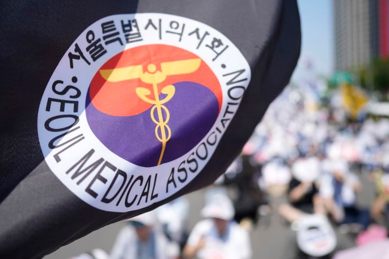 A flag of Seoul Medical Association flutters in the wind during a rally against the government's medical policy in Seoul, South Korea, Tuesday, June 18, 2024. South Korean officials issued return-to-work orders for doctors participating in a one-day walkout Tuesday as part of a protracted strike against government plans to boost medical school admissions, starting next year. (AP Photo/Lee Jin-man)