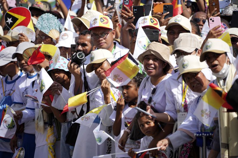 People wait for Pope Francis' arrival outside of the Dili Presidente Nicolau Lobato International Airport in Dili, East Timor, Monday, Sept. 9, 2024. (AP Photo/Firdia Lisnawati)