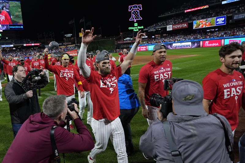 Philadelphia Phillies' Bryce Harper, center left, celebrates after winning a baseball game against the Chicago Cubs to clinch the NL East title, Monday, Sept. 23, 2024, in Philadelphia. (AP Photo/Matt Slocum)