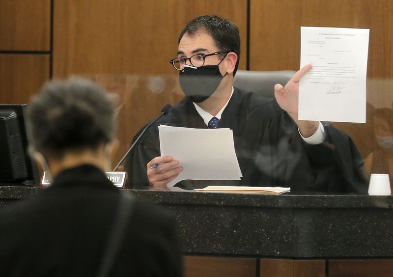 Cobb County Chief Magistrate Judge Brendan Murphy holds up paperwork related to the extended eviction moratorium and explains what it entails to a landlord and the tenant on Tuesday, Aug. 10, 2021. The extended moratorium protects tenants from eviction in counties where there is a large spread of COVID-19. (Christine Tannous / christine.tannous@ajc.com)