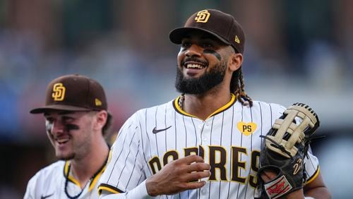 San Diego Padres right fielder Fernando Tatis Jr., right, jokes with teammate centerfielder Jackson Merrill during the seventh inning of a baseball game Monday, Sept. 2, 2024, in San Diego. (AP Photo/Gregory Bull)