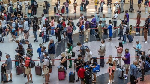 Travelers line up in the domestic terminal atrium waiting to go through security screening at the main security checkpoint at Hartsfield-Jackson International Airport in Atlanta ahead of the Fourth of July holiday, on Friday, June 28, 2024. (John Spink/AJC)