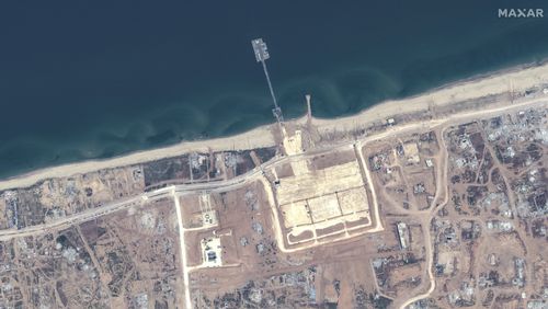 This image released by Maxar Technologies shows the overview of the new pier off Gaza and aid trucks on Saturday, May 18, 2024. (Satellite image ©2024 Maxar Technologies via AP)