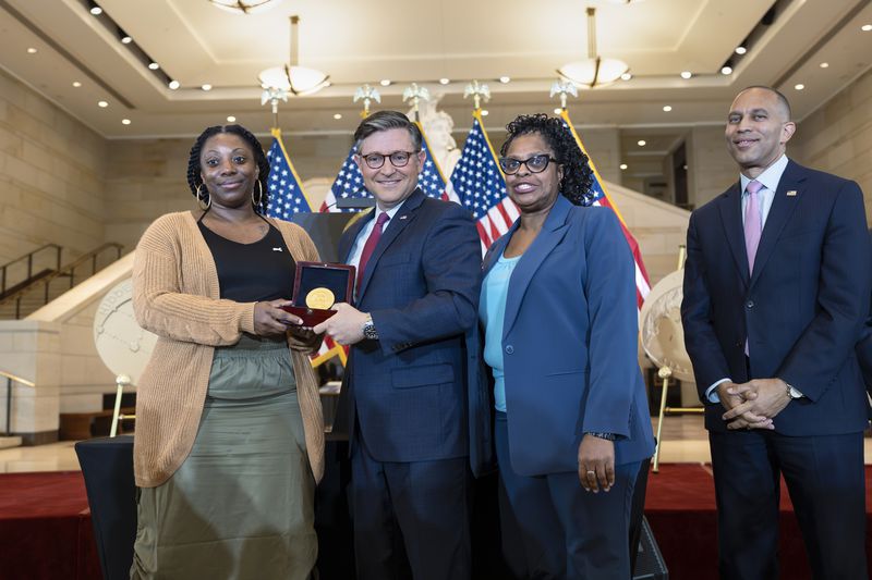 House Speaker Mike Johnson, R-La., center, presents a Congressional Gold Medal posthumously honoring NASA mathematician Mary Jackson to her granddaughters KaShawnta Lee, left, and Wanda Jackson, joined at right by House Minority Leader Hakeem Jeffries, D-N.Y., at a celebration of the Black women of NASA who contributed to the space race and who were the subject of the book and movie "Hidden Figures," at the Capitol in Washington, Wednesday, Sept. 18, 2024. (AP Photo/J. Scott Applewhite)