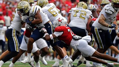 Louisville defensive back M.J. Griffin (26) attempts to bring down Georgia Tech running back Trelain Maddox (28) during the second half of an NCAA college football game in Louisville, Ky., Saturday, Sept. 21, 2024. (AP Photo/Timothy D. Easley)