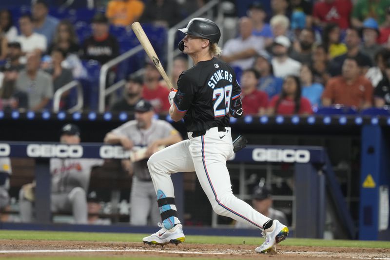 Miami Marlins' Kyle Stowers (28) hits a single during the first inning of a baseball game against the Atlanta Braves, Friday, Sept. 20, 2024, in Miami. (AP Photo/Marta Lavandier)