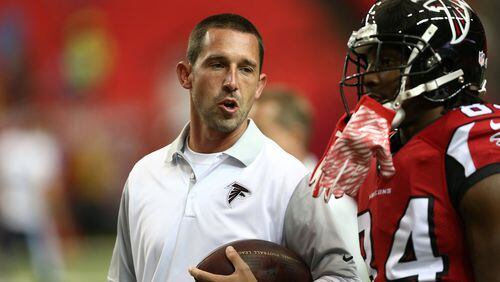 Atlanta Falcons Offensive coordinator Kyle Shanahan, left speaks with wide receiver Roddy White (84) before the first half of an NFL football preseason game between the Atlanta Falcons and the Tennessee Titans, Friday, Aug. 14, 2015, in Atlanta. (AP Photo/John Bazemore)