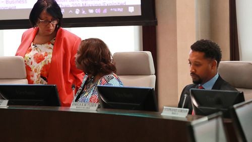 East Point Councilwoman Nanette Saucier (standing), who is trying to get a judge to determine whether Councilman Joshua B. Butler IV (right) should be removed from City Council because of issues with his previous conviction, confers with Councilwoman Karen Rene during the East Point City Council meeting on Monday, June 3, 2019, in East Point. Curtis Compton/ccompton@ajc.com