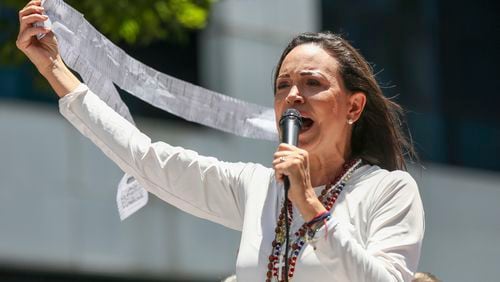 Opposition leader Maria Corina Machado displays vote tally sheets during a protest against the reelection of President Nicolás Maduro one month after the disputed presidential vote which she says the opposition won by a landslide, in Caracas, Venezuela, Wednesday, Aug. 28, 2024. (AP Photo/Cristian Hernandez)