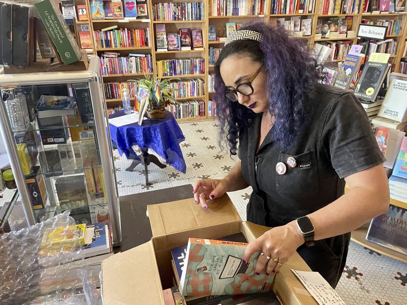 Becka Robbins, events manager and founder of the "Books Not Bans" program at Fabulosa Books, packs up LGBTQ+ books to be sent to parts of the country where they are censored on Thursday, June 27, 2024 at the Castro District of San Francisco. The bookstore is sending LGBTQ+ books to where they are censored to counter the rapidly growing effort by anti-LGBTQ+ activists and lawmakers to ban queer-friendly books from public schools and libraries. (AP Photo/Haven Daley)