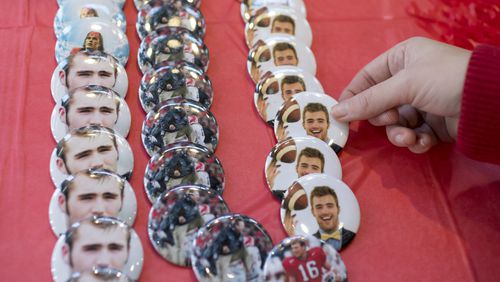 Emily Startup, a second year masters student at the University of Georgia, picks up a Jake Fromm button at Tailgate Georgia in Athens, on Sunday, Jan. 7, 2018.