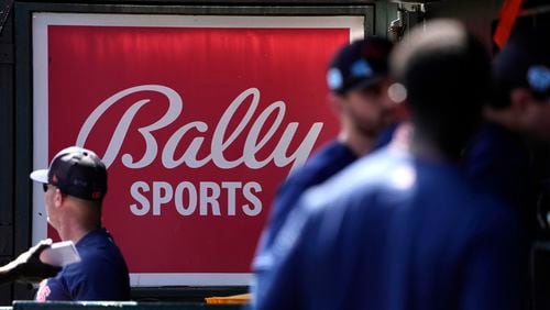 FILE - A Bally Sports sign hangs in a dugout before a spring training baseball game between the St. Louis Cardinals and the Houston Astros, March 2, 2023, in Jupiter, Fla. (AP Photo/Jeff Roberson, File)