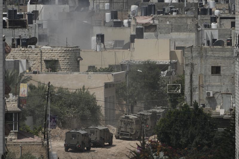 Israeli armoured vehicles move during a military operation in the West Bank Jenin refugee camp, Saturday, Aug. 31, 2024. (AP Photo/Majdi Mohammed)