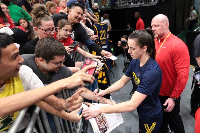 Indiana Fever guard Caitlin Clark signs autographs before the team's WNBA basketball game against the Seattle Storm, Wednesday, May 22, 2024, in Seattle. (AP Photo/Jason Redmond)