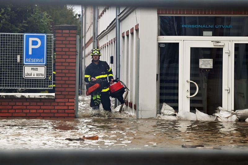 A firefighter wades through flooded streets in Opava, Czech Republic, Sunday Sept. 15, 2024. (Jaroslav Ozana/CTK via AP)