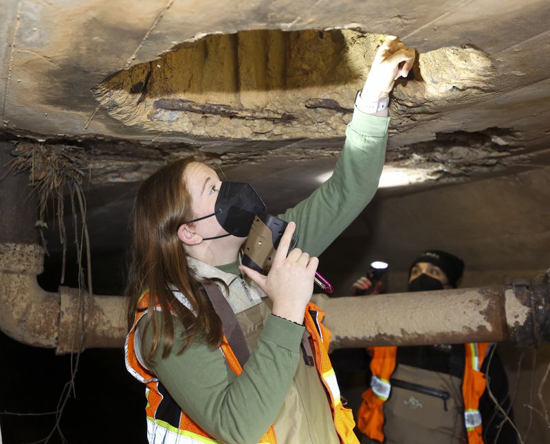 DNR wildlife biologist Emily Ferrall uses a light to look for bats as they survey a culvert in northeast Georgia on Wed., Dec. 6, 2023. (Jason Getz / Jason.Getz@ajc.com)