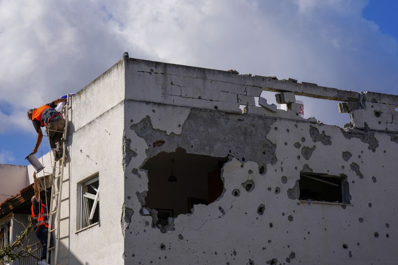 Israeli security forces work at a house hit by a rocket fired from Lebanon, in Kiryat Bialik, northern Israel, on Sunday, Sept. 22, 2024. (AP Photo//Ariel Schalit)